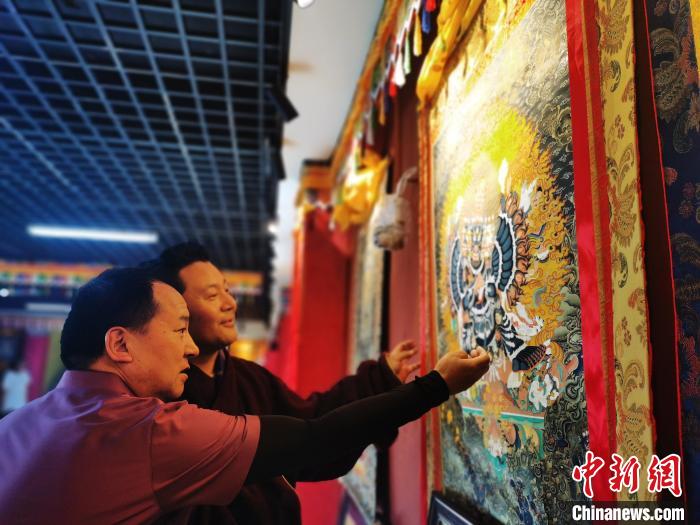 圖為久美尖措展示唐卡作品。　張?zhí)砀?攝