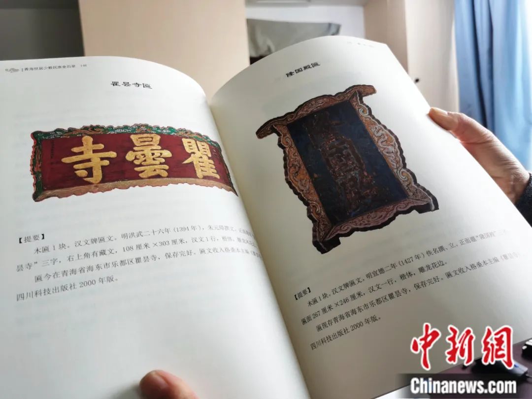 古籍保護(hù)人員展示介紹明代朱元璋撰寫的青海瞿曇寺匾(左)的出版書籍。張?zhí)砀?攝