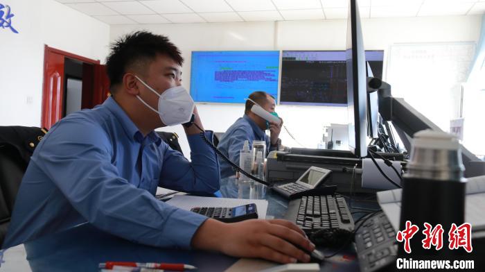 圖為貨運(yùn)調(diào)度人員與外勤工作人員聯(lián)系掌握車輛裝載情況?！±钌?攝