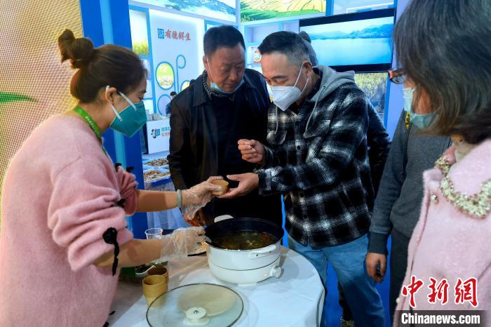 圖為杭州市民品嘗茶卡羊肉?！±铍h 攝