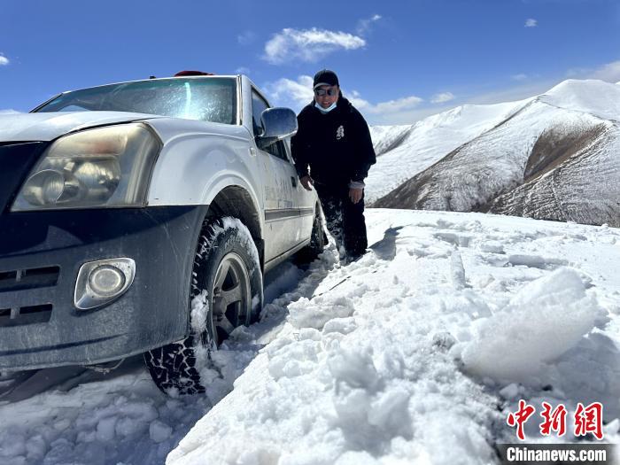 圖為生態(tài)管護人員準備在雪地推車?！《“瓦_杰 攝