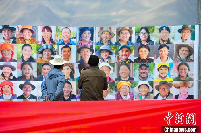 圖為當(dāng)?shù)孛癖娫谟^看展板上的笑臉?！垈?攝