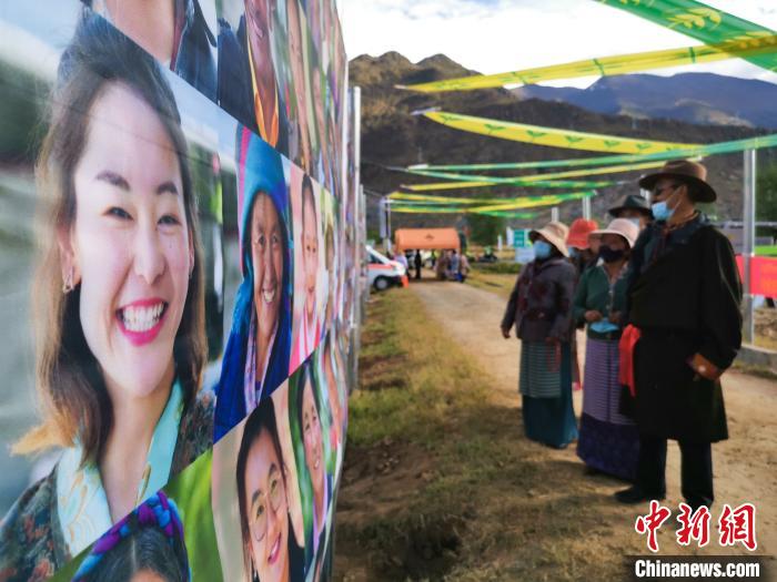 圖為當(dāng)?shù)孛癖娫谟^看展板上的笑臉?！垈?攝