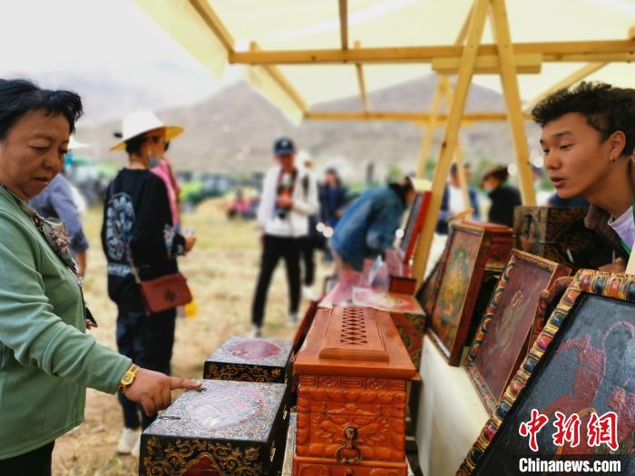 圖為拉薩市民在特色農(nóng)畜產(chǎn)品展示展銷會上選購商品?！垈?攝