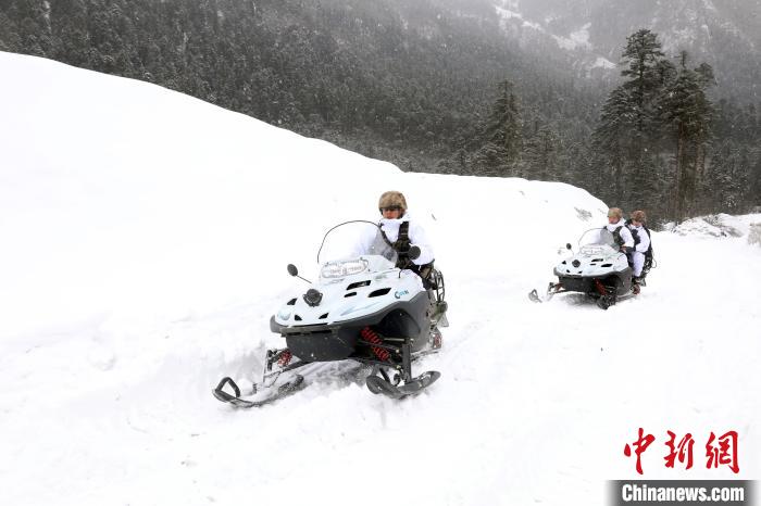 圖為雪地摩托車開路。　薛金博 攝