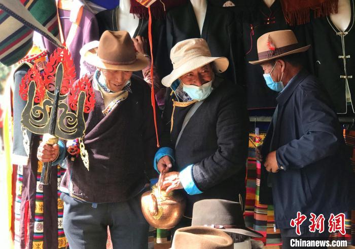 圖為三位藏族老人在集市上聊天交談?！∪轿木?攝