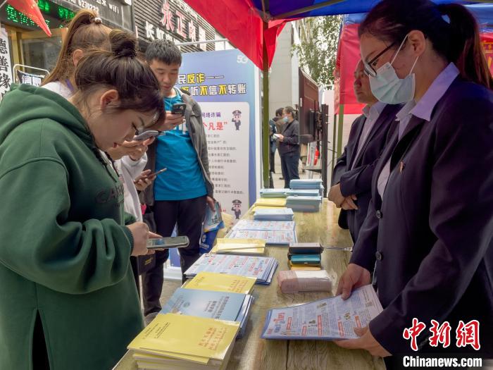 圖為工作人員正在向路過市民介紹國家反詐中心軟件的功能。　謝牧 攝