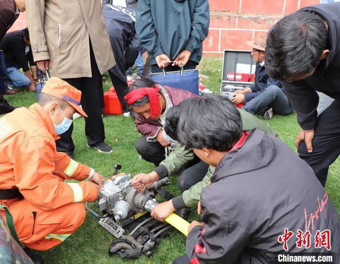 圖為森林消防員為護林員講解滅火裝備的使用方法?！〔际猩窒乐ш?供圖