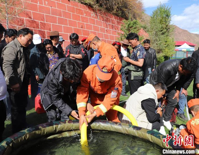 圖為森林消防員為護林員講解滅火裝備的使用方法。　昌都市森林消防支隊 供圖