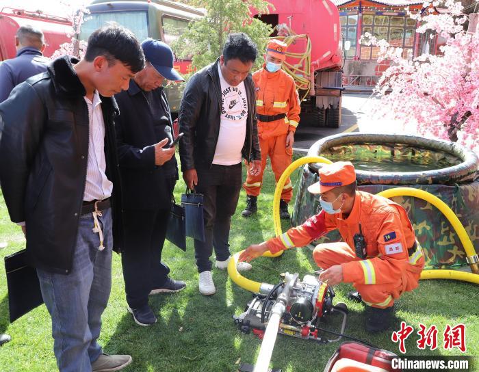 圖為森林消防員為護林員講解滅火裝備的使用方法?！〔际猩窒乐ш?供圖