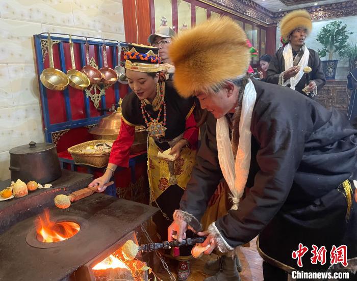 圖為人們?cè)诨鹕峡竟?jié)日美食“結(jié)達(dá)”?！∪轿木?攝