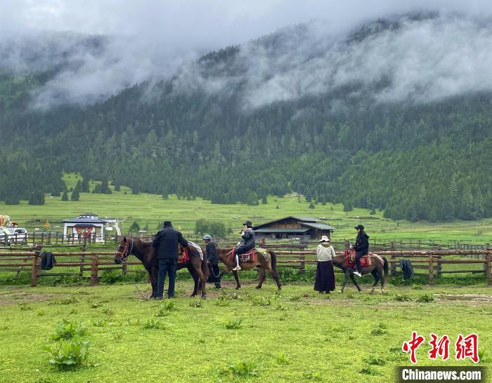 6月10日，游客在魯朗小鎮(zhèn)高山牧場景區(qū)體驗騎馬?！∪轿木?攝