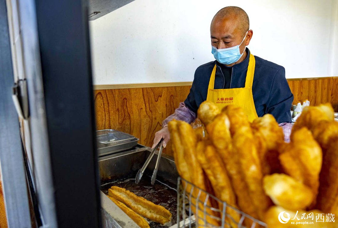 早餐店老板正在炸油條。人民網(wǎng) 次仁羅布攝
