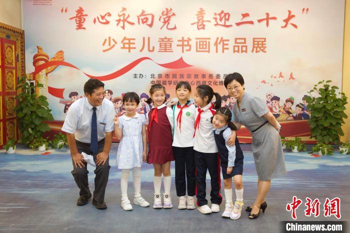 圖為與會嘉賓與入選畫作的“小作者”們在展覽上合影?！≈袊貙W(xué)研究中心供圖