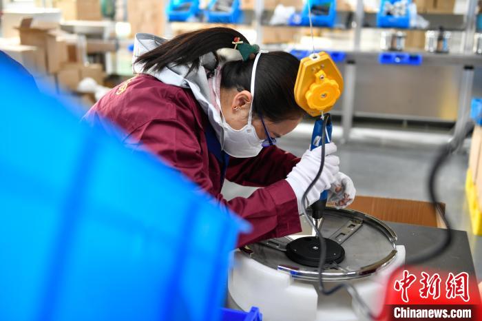 圖為工人正在組裝炊具?！∝暩聛硭?攝