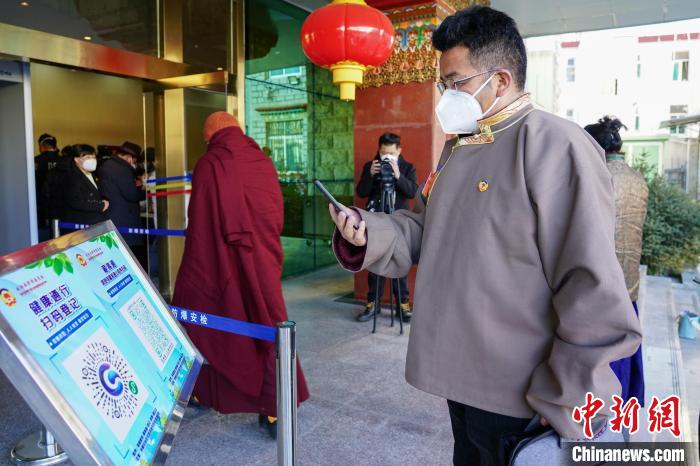 圖為政協(xié)委員掃場所碼進入會場。　江飛波 攝