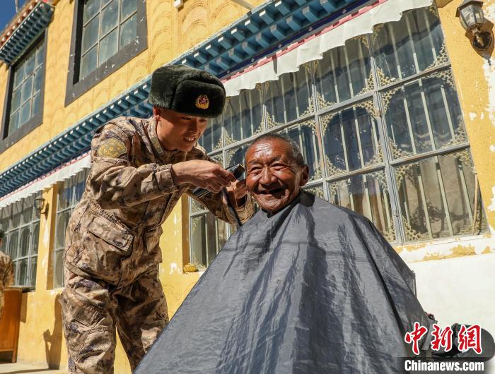 圖為阿里軍分區(qū)某邊防團(tuán)官兵為駐地群眾理發(fā)迎藏歷新年?！〉┰鰝愔?攝