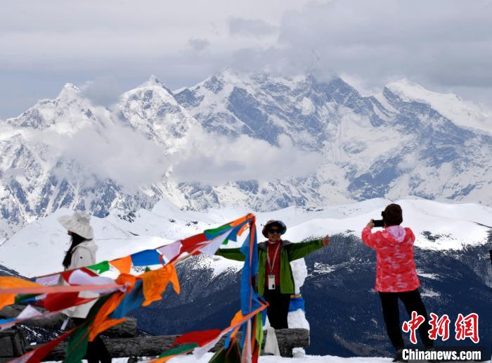 圖為5月14日，西藏林芝色季拉山觀景臺(tái)，游客與南迦巴瓦峰合影?！±盍?攝