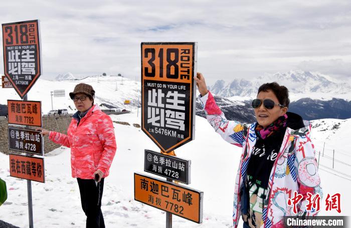 圖為5月14日，西藏林芝色季拉山觀景臺(tái)，游客與南迦巴瓦峰合影?！±盍?攝